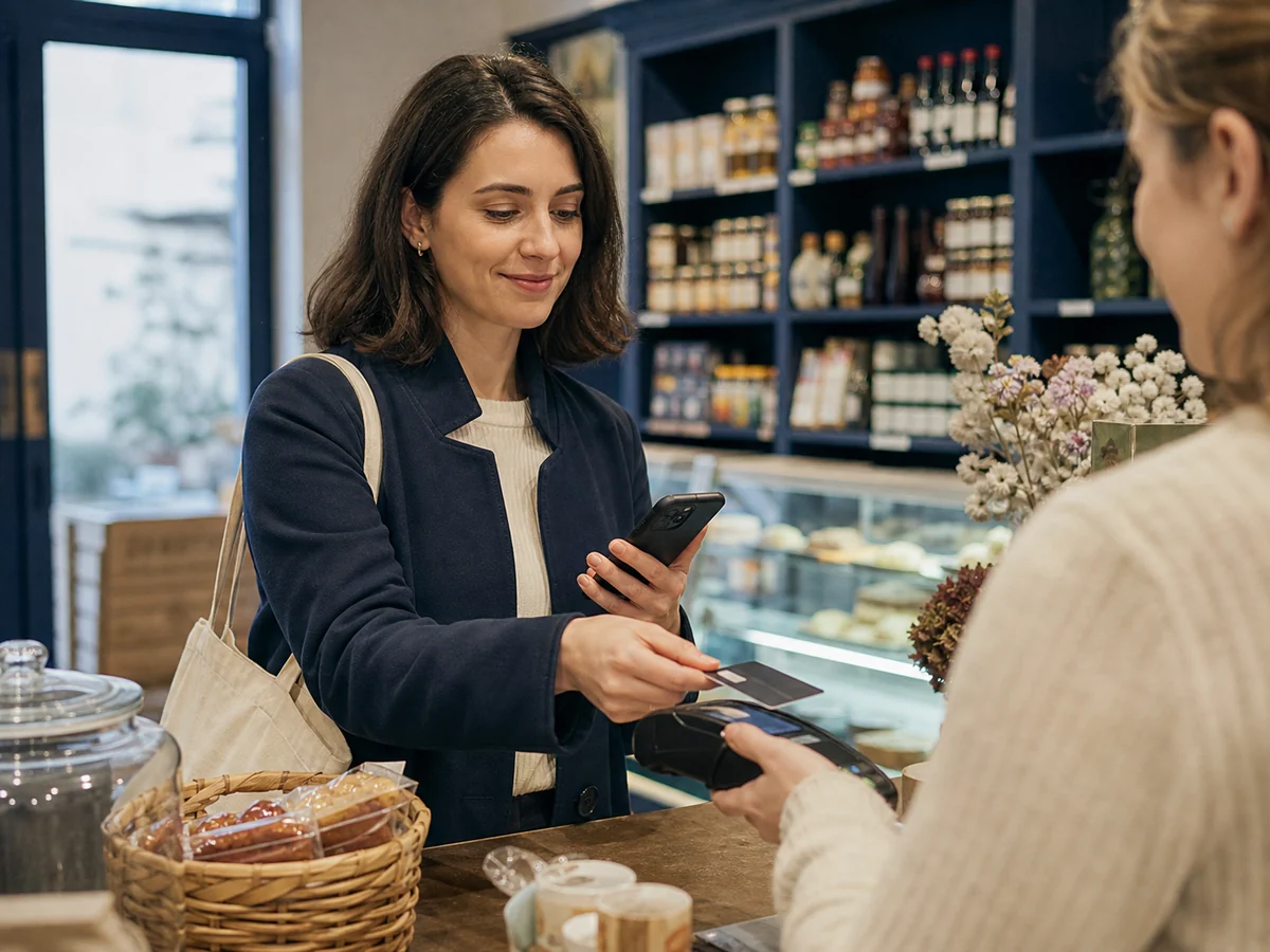 droit au compte — une personne règle un achat avec la carte fournie parmi les services bancaires de base.