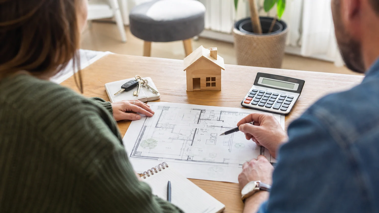 prêt à taux zéro (PTZ) — un couple étudie le plan de son futur logement avec des clés et une calculatrice.