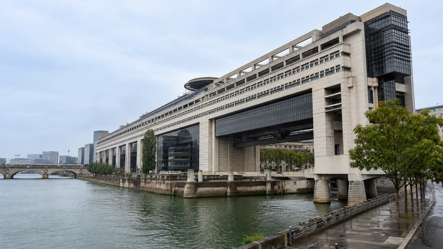 Illustration du ministère de l’Économie et des Finances à Bercy, vu depuis les quais de Seine, avec ses grandes structures surplombant le fleuve.