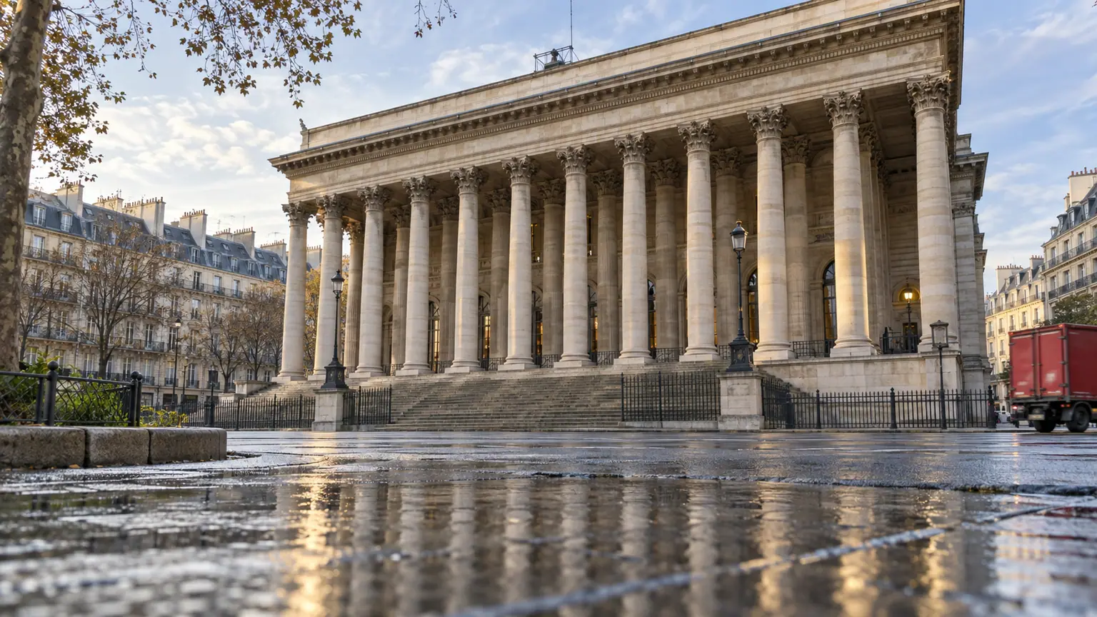 Bourse de Paris après la Fed — colonnade néoclassique au petit matin, pavement mouillé et camion au loin.