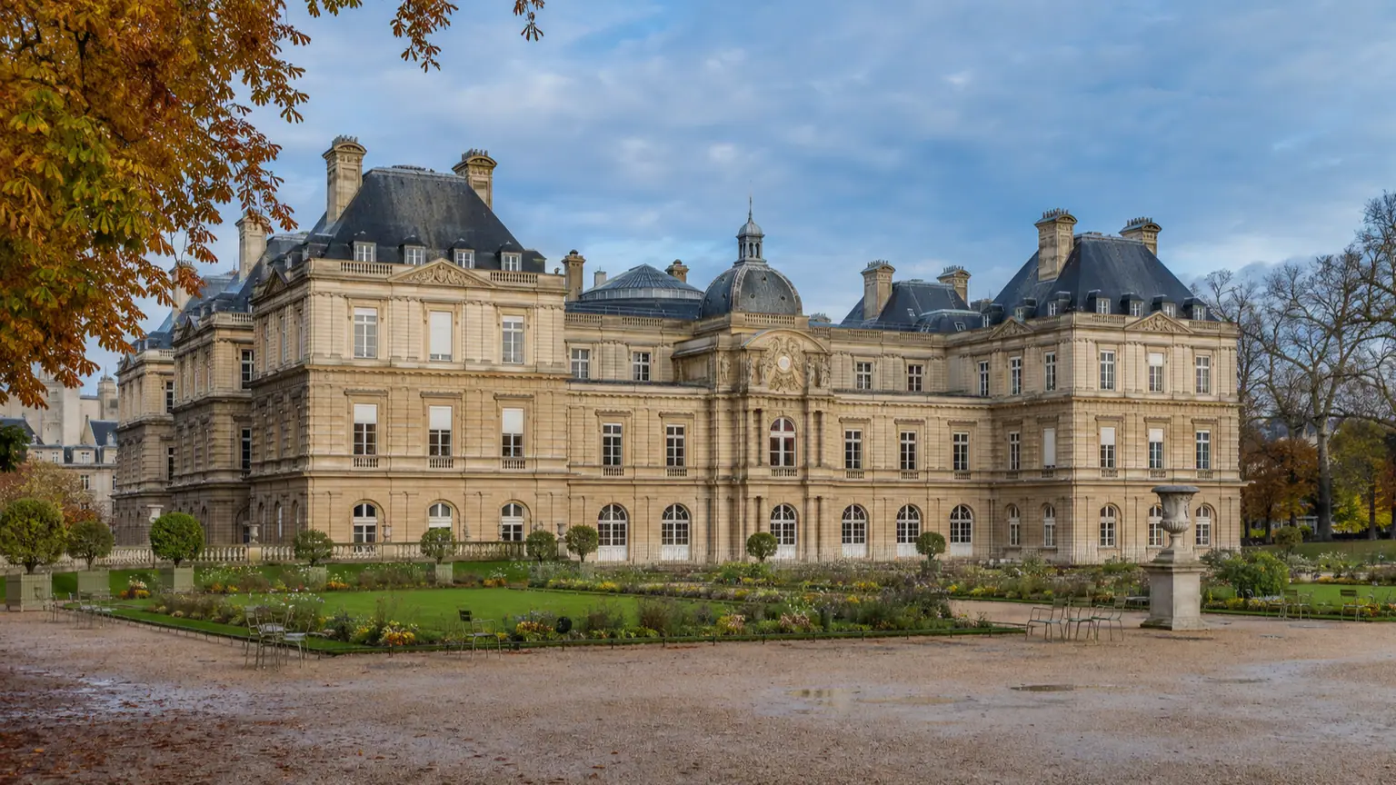 Cap fiscal de cinq ans pour les entreprises — Palais du Luxembourg vu depuis son jardin, façade de pierre, allées humides et feuillage d’automne.