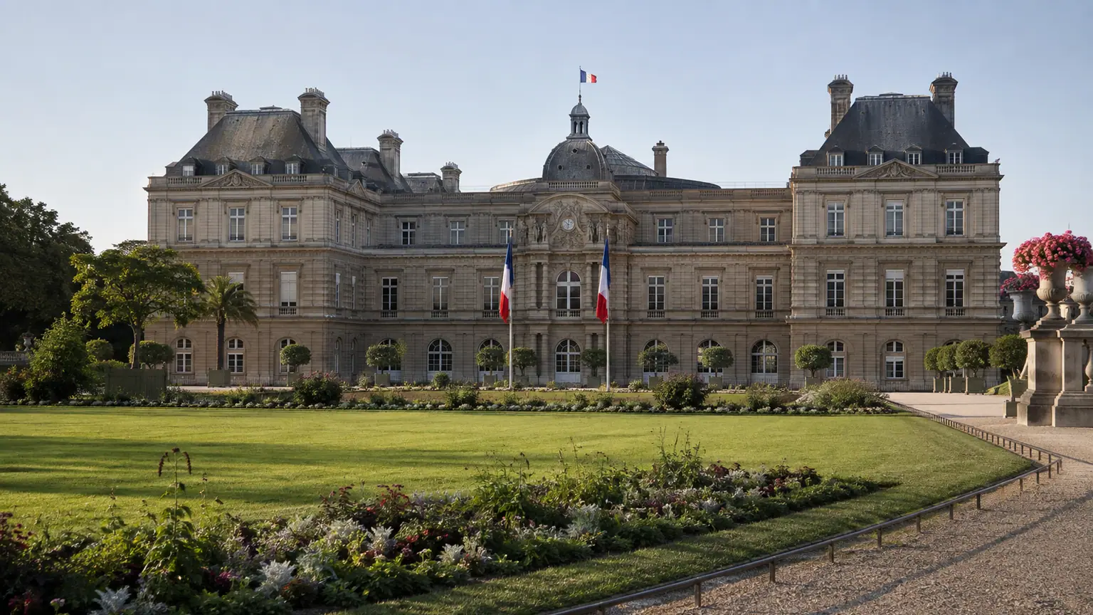 Fiscalité des entreprises proposée par le Sénat — façade du Palais du Luxembourg vue depuis le jardin, avec pelouse, massifs fleuris et drapeaux français.