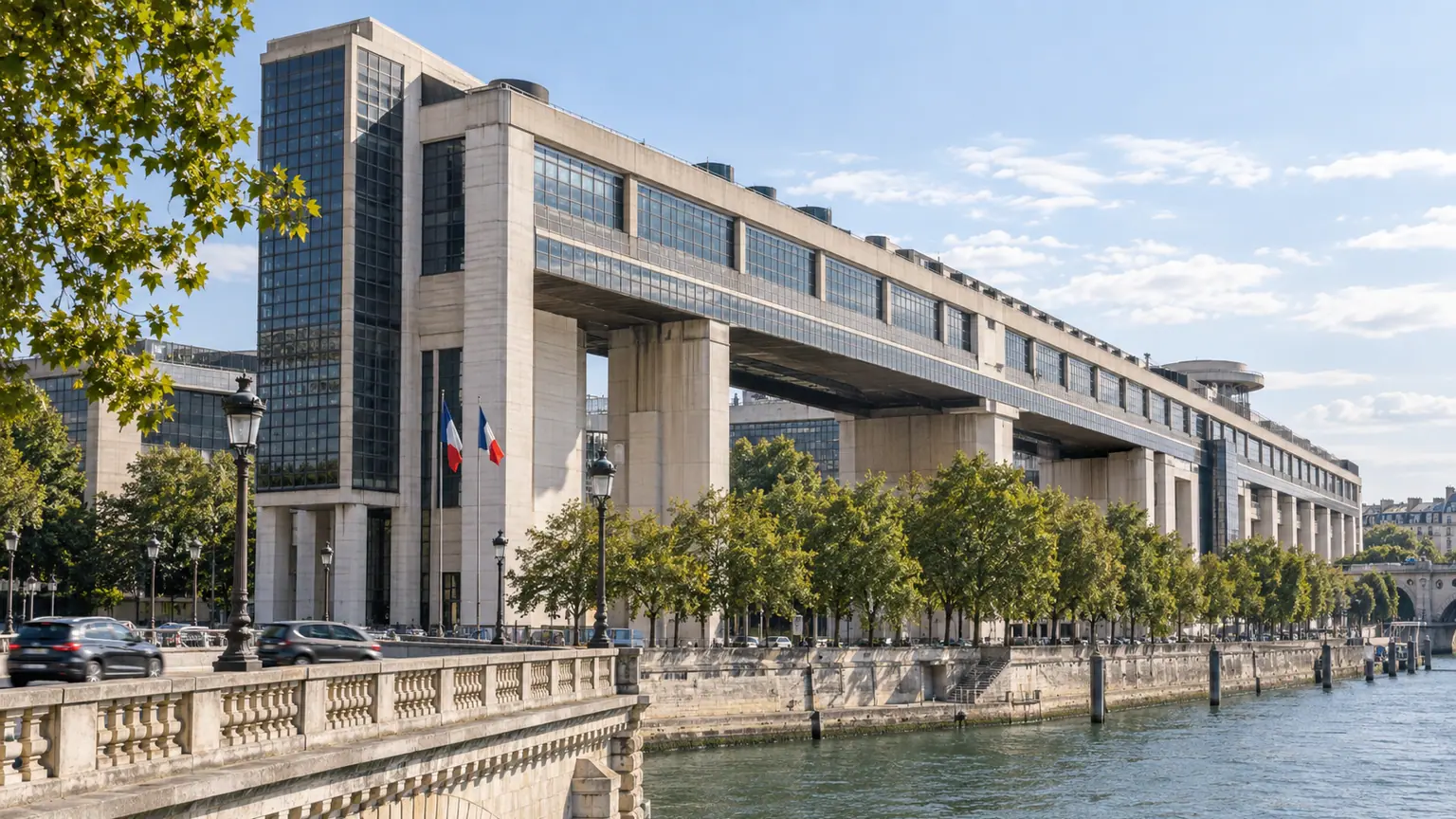 Prévision de croissance du gouvernement — façade de Bercy au bord de la Seine, avec drapeaux français, arbres et circulation parisienne.