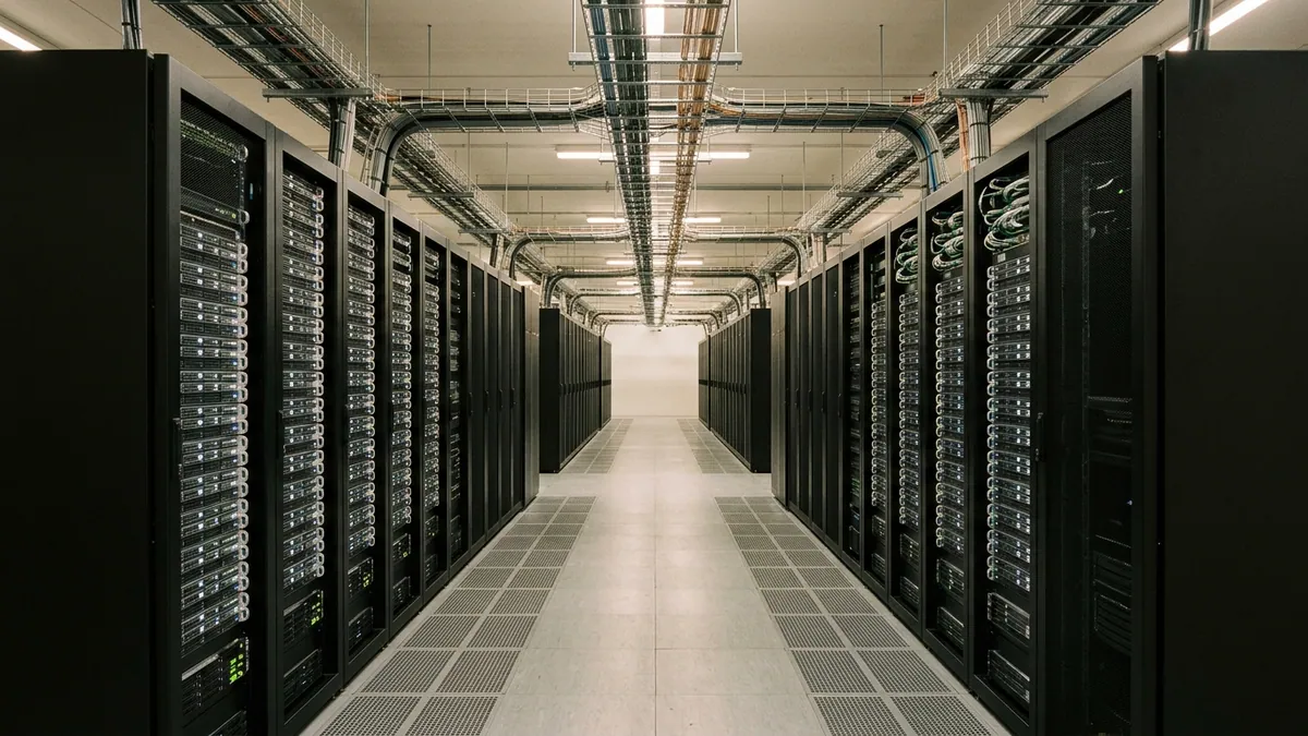Croissance mondiale portée par l'intelligence artificielle — allée centrale d'un centre de données avec baies de serveurs et plancher ventilé.