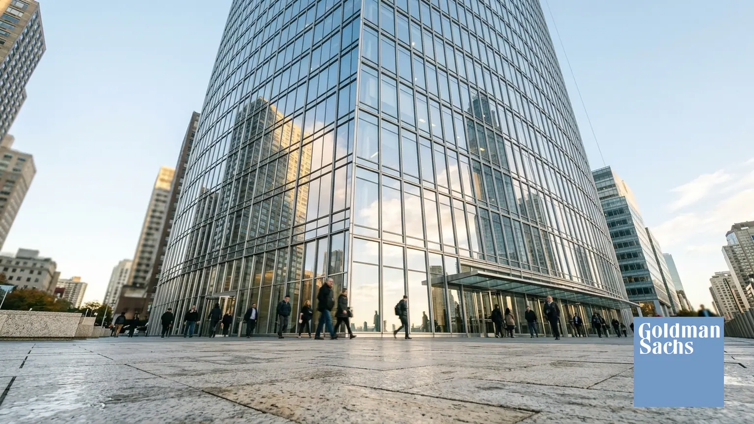 Bénéfice net de Goldman Sachs à New York — tour en verre et acier à Lower Manhattan et logo officiel incrusté en bas à droite.