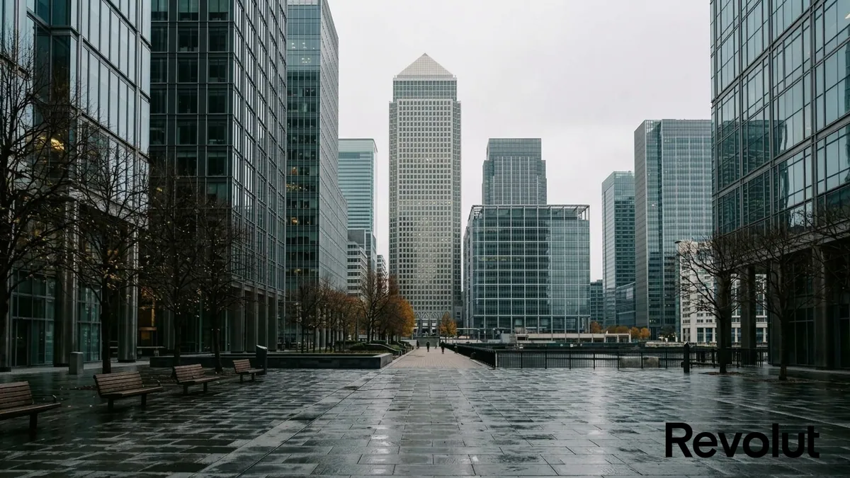 Revolut face aux acteurs bancaires européens — façade contemporaine de verre et d'acier à Canary Wharf à Londres sous un ciel d'automne, logo officiel de l'enseigne en incrustation.