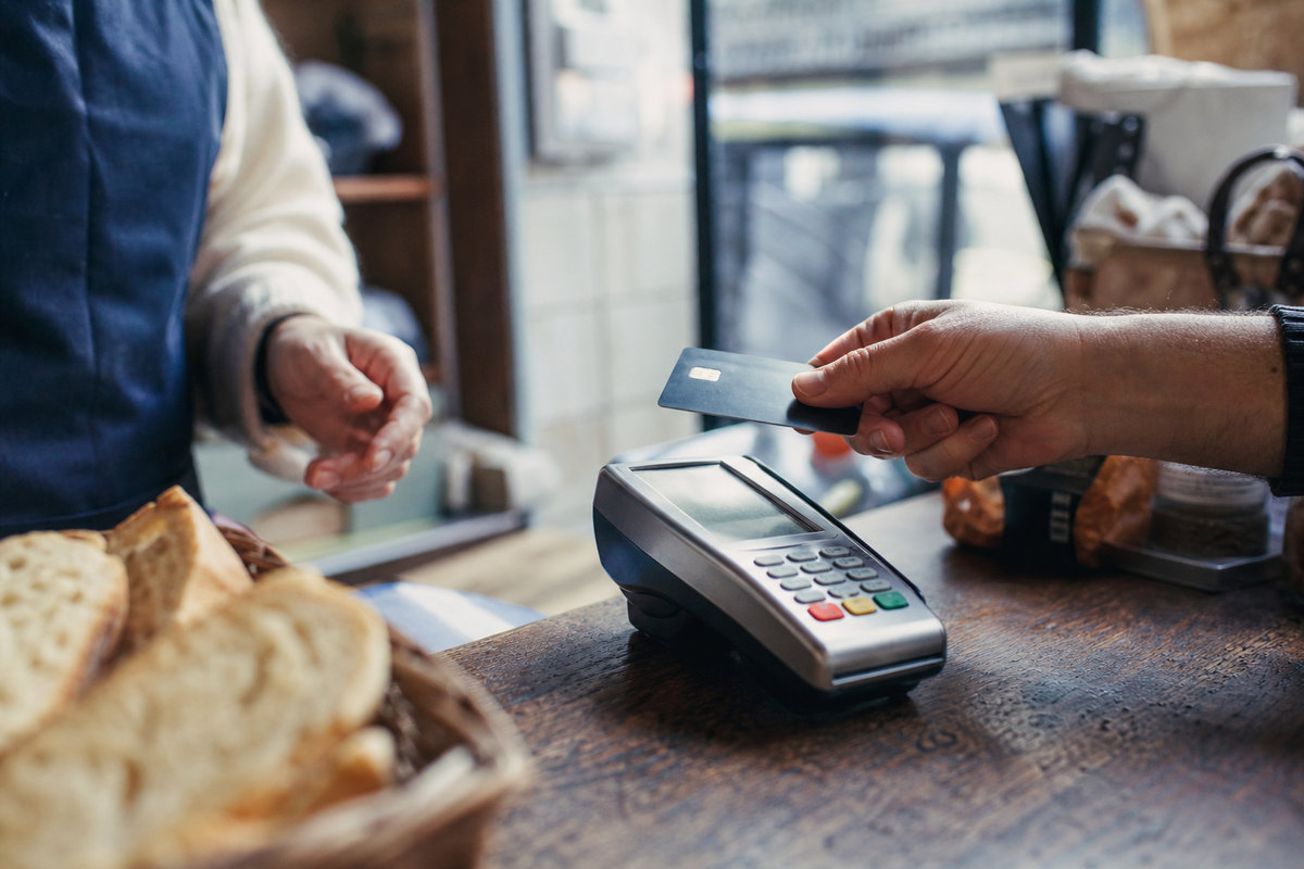 Paiement par carte avec terminal de paiement en magasin, scène photojournalistique réaliste en France, sans texte ni logo.